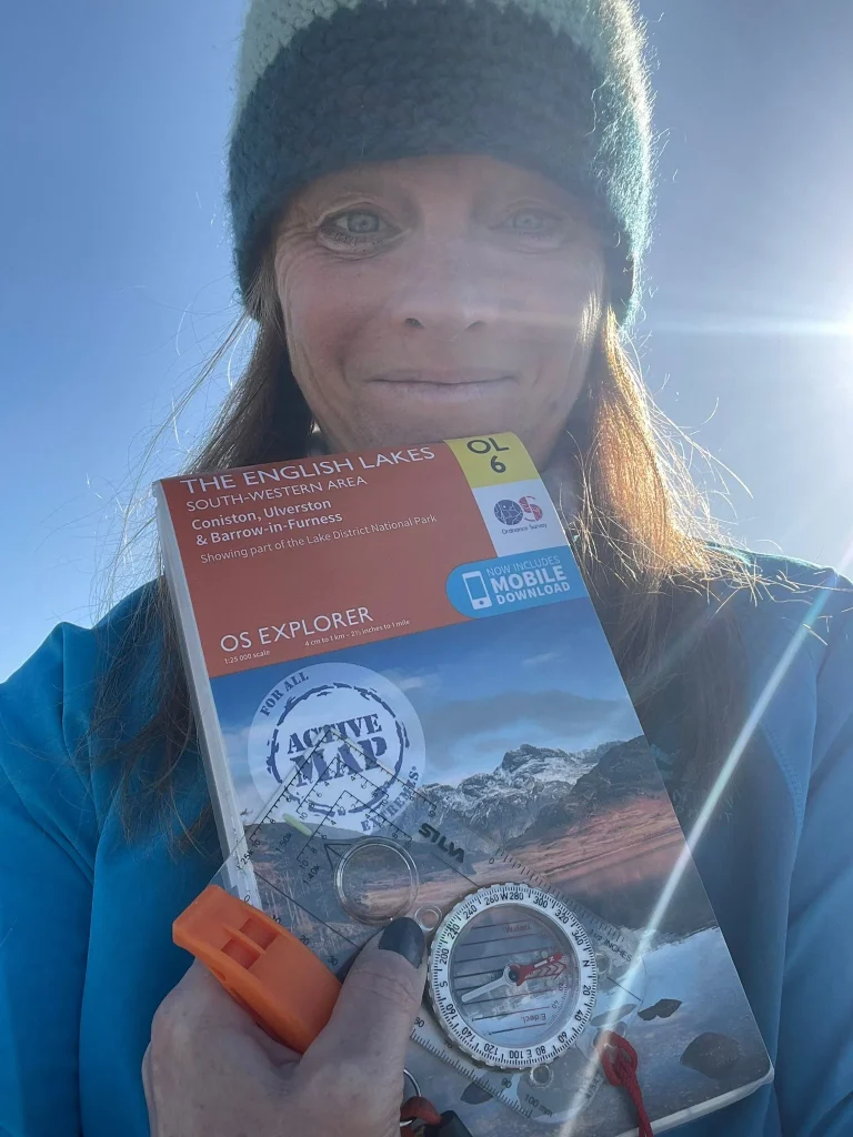 Ros holding a map and compass used for mountain navigation training