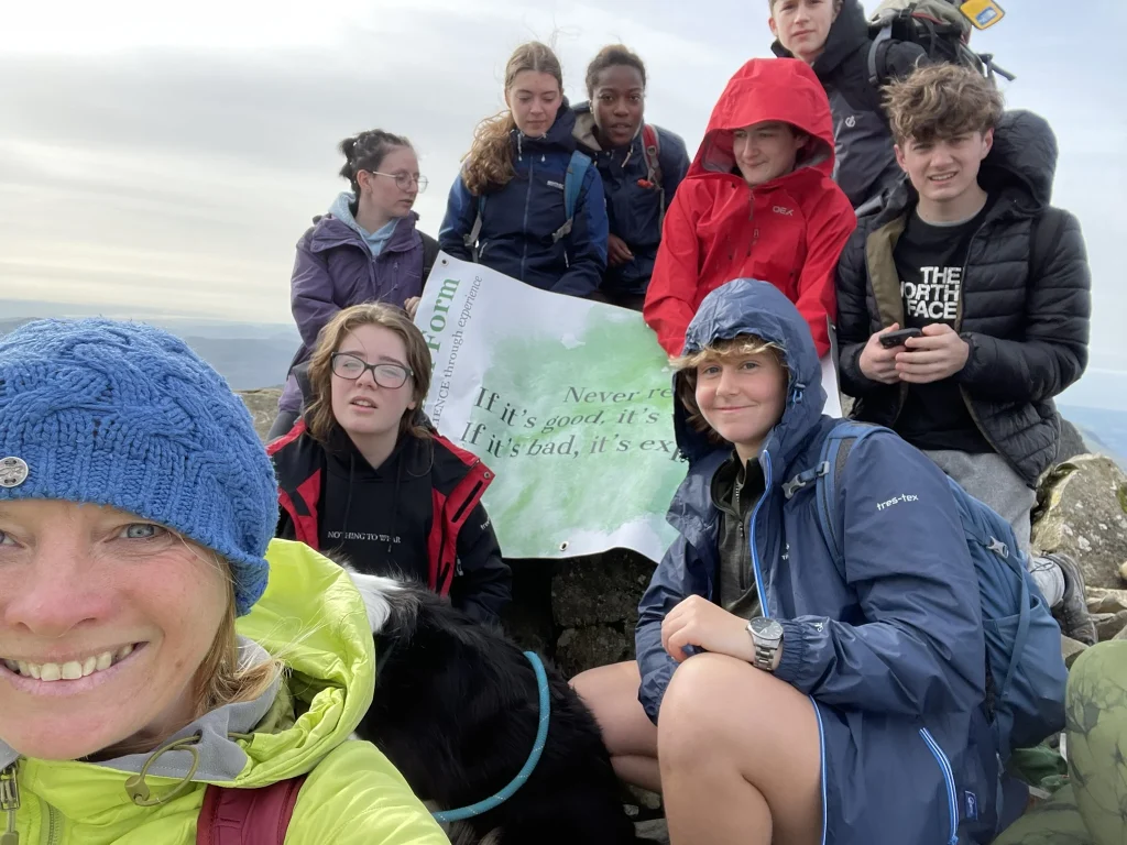 Ros leading a group walk on a Lake District mountain summit