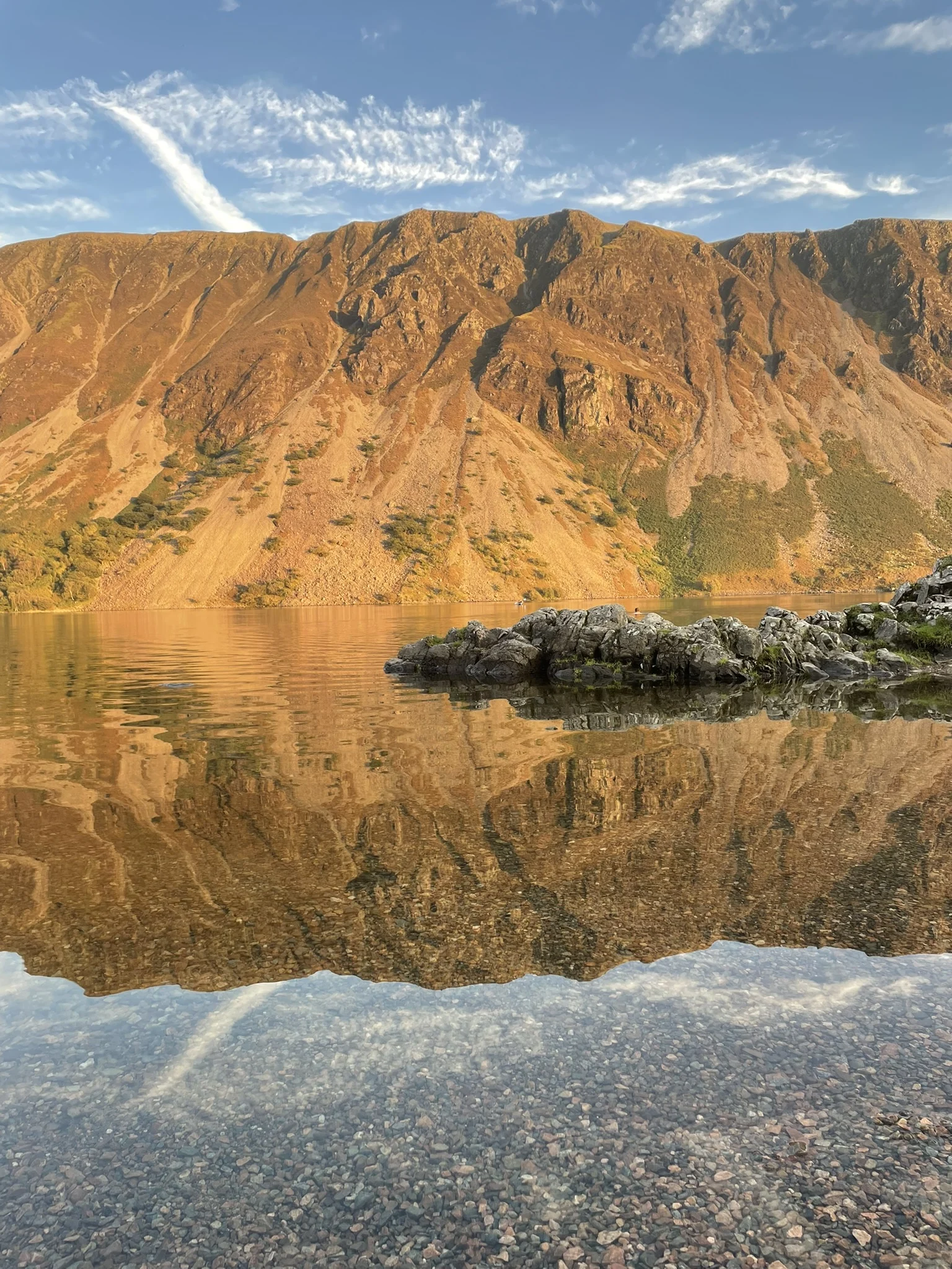 Golden mountain reflected in still water of a Lake District lake