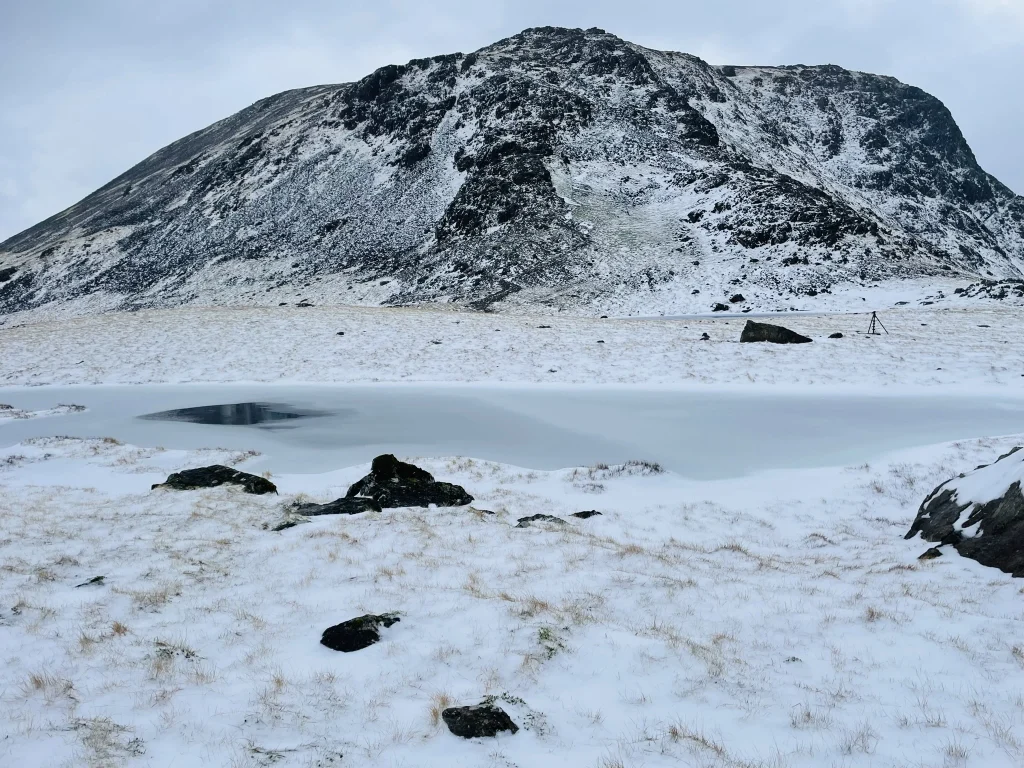 Snow-covered Kirk Fell with frozen tarn near Great Gable and Green Gable