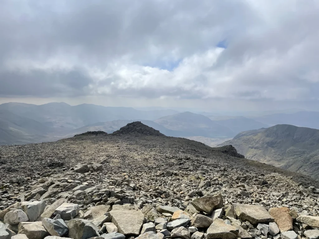 Rocky summit plateau with views across Lake District fells near Scafell Pike