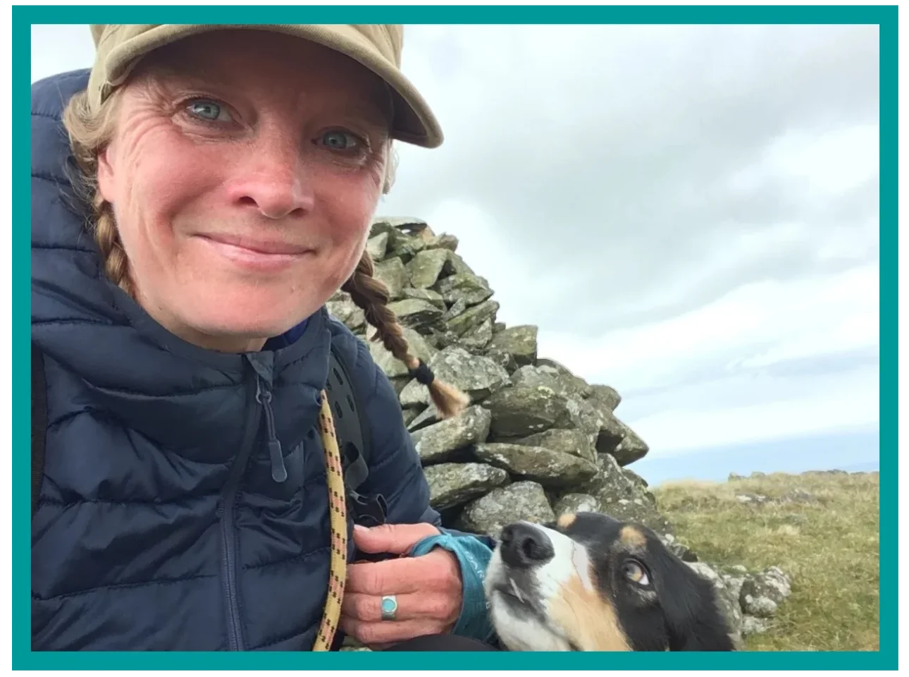 Way Out West guide with Blea the dog beside a mountain cairn
