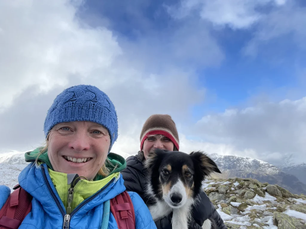 Ros and another walker with her dog Blea on a snowy Lake District summit - Women Only Walks